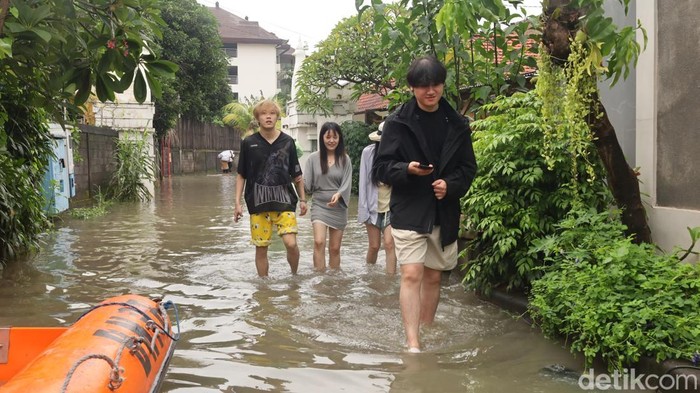 1765710391971-sejumlah-turis-asing-menerobos-banjir-di-jalan-gunung-athena-denpasar-bali-minggu-14122025-foto-aryo-mahendrodetikbali-1765695076030_169